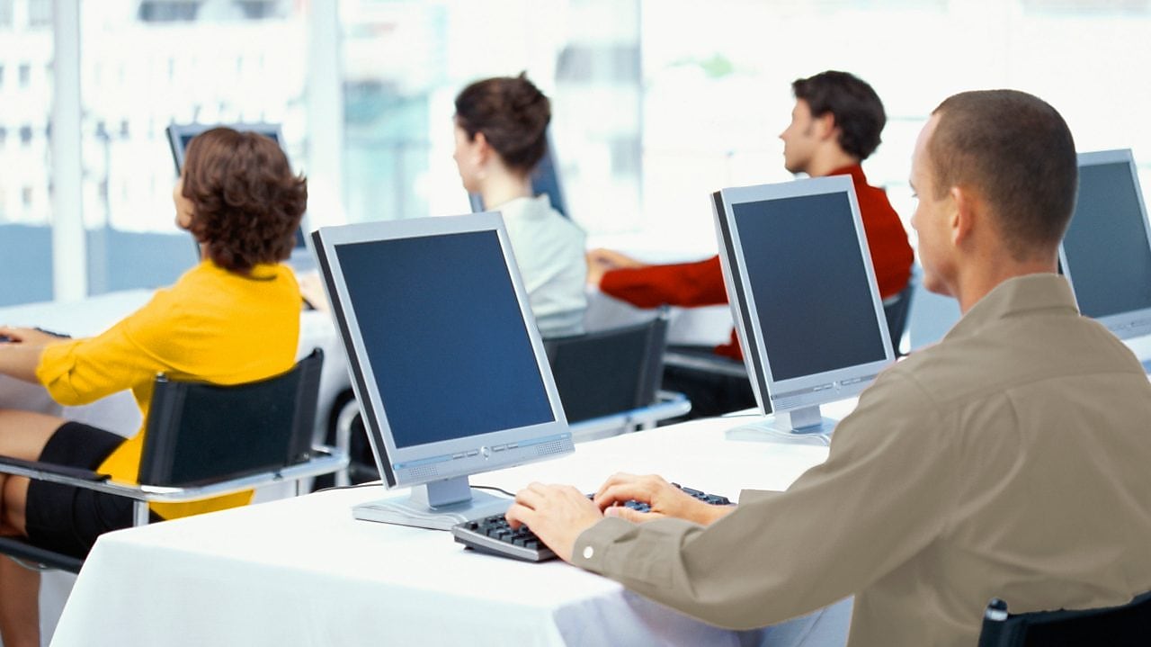 Punonjës që përdorin kompjutera në zyrë