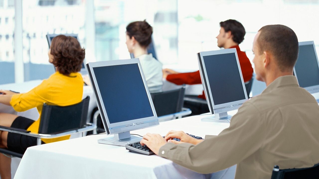 Punonjës që përdorin kompjutera në zyrë