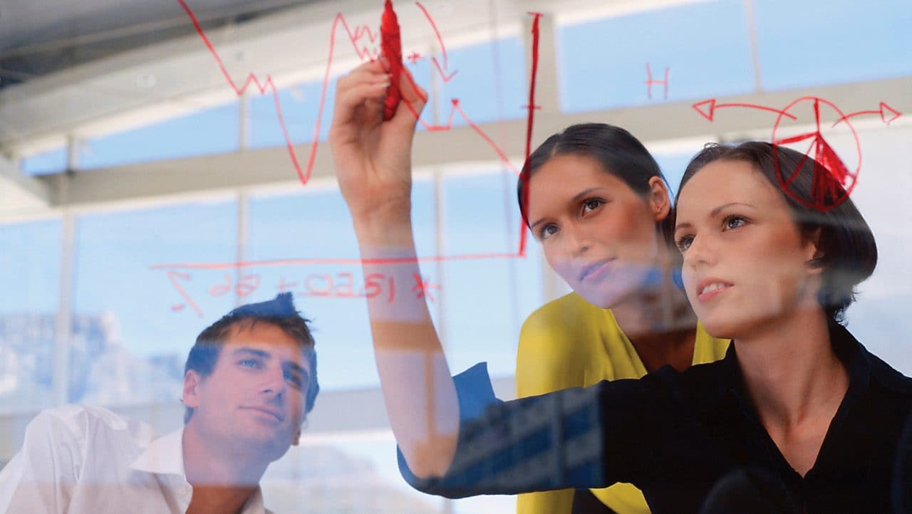 Një sipërmarrëse duke vizatuar grafikë në xham