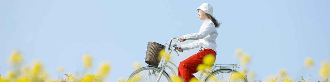 Një vajzë duke pedaluar biçikletën në fushë