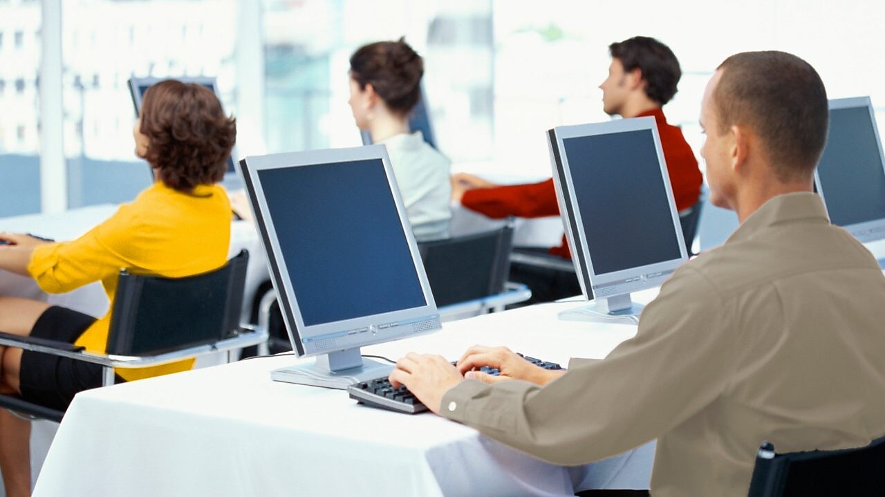 Punonjës që përdorin kompjutera në zyrë