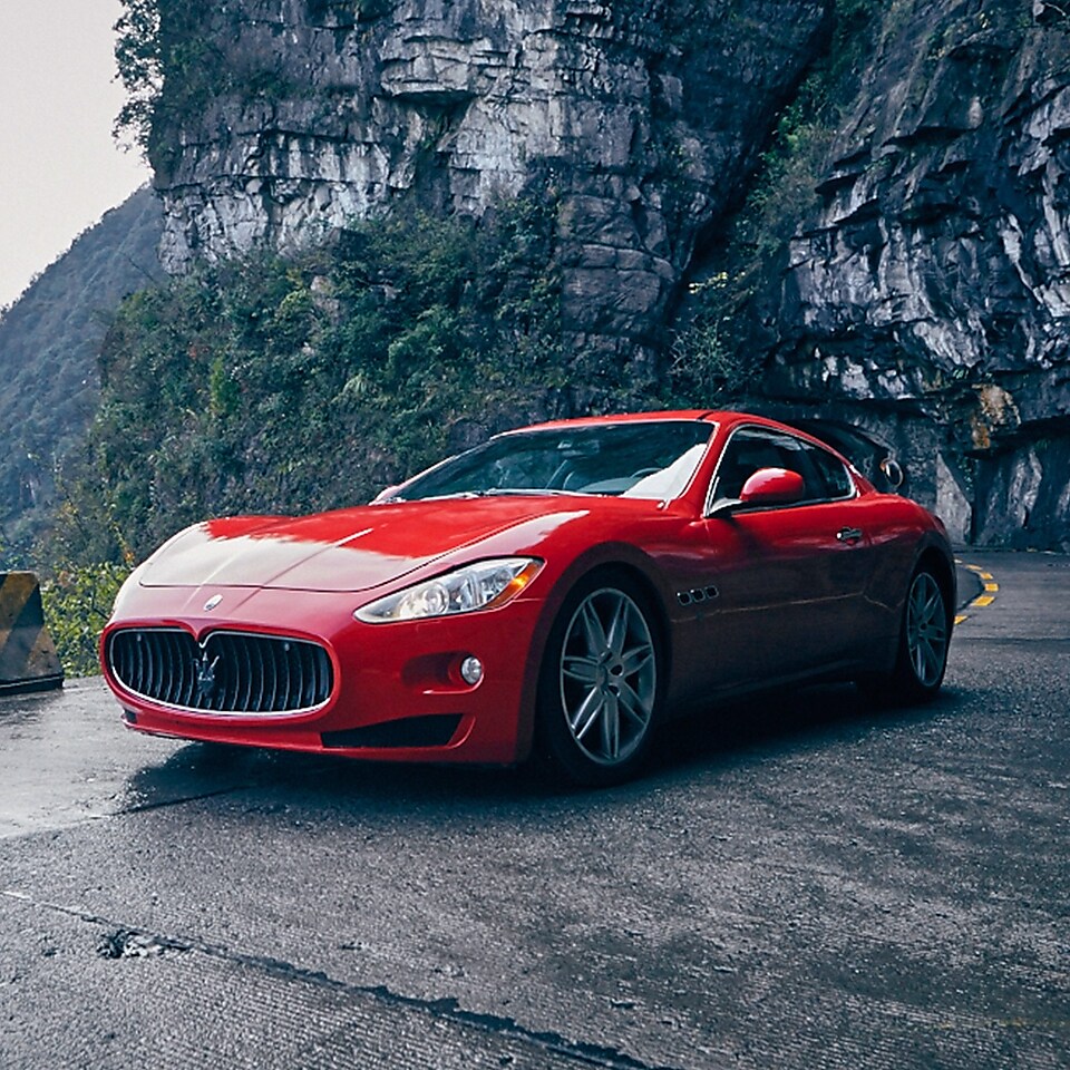 Një Maserati i kuq me produktin standard Shell Helix Ultra qëndron me krenari në një rrugë piktoreske malore