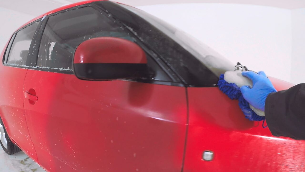 Larja e duarve nga jashtë e një makine të kuqe