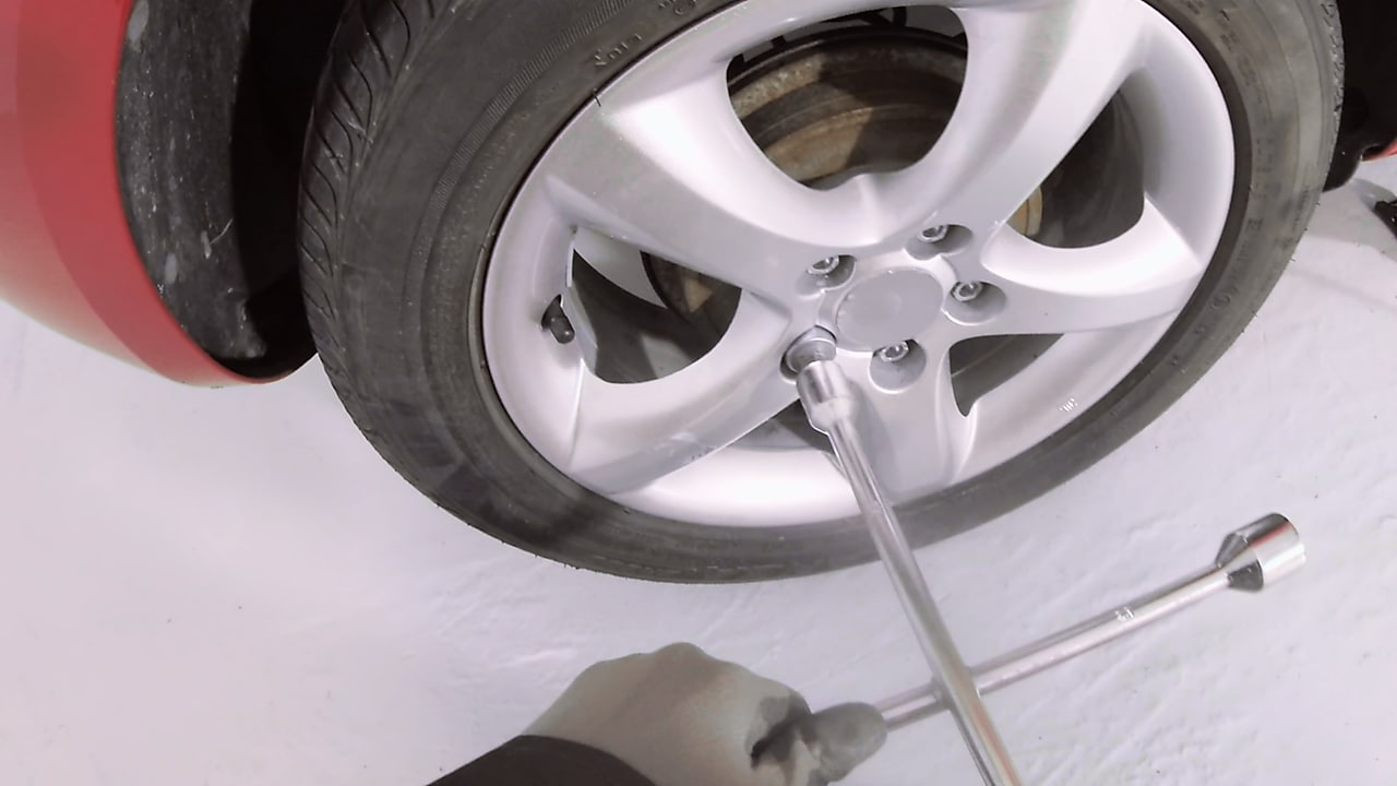 hands loosening the wheel nuts