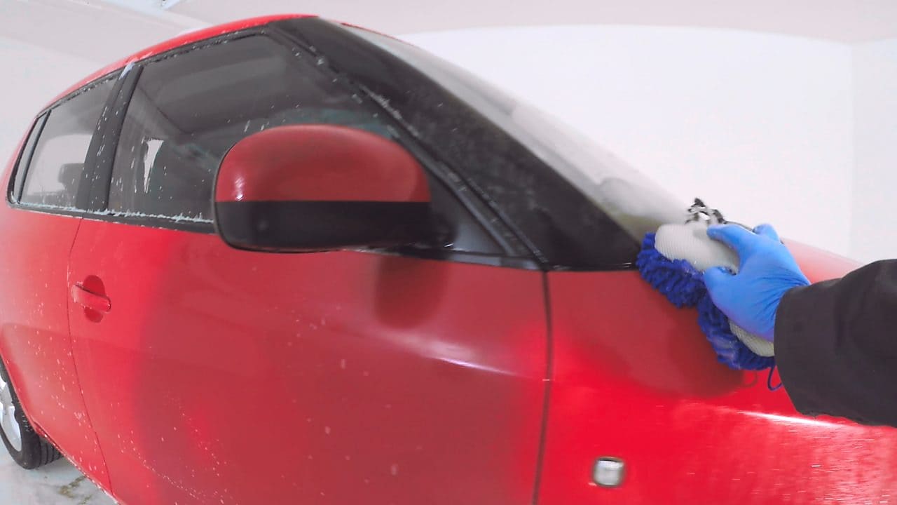 Larja e duarve nga jashtë e një makine të kuqe