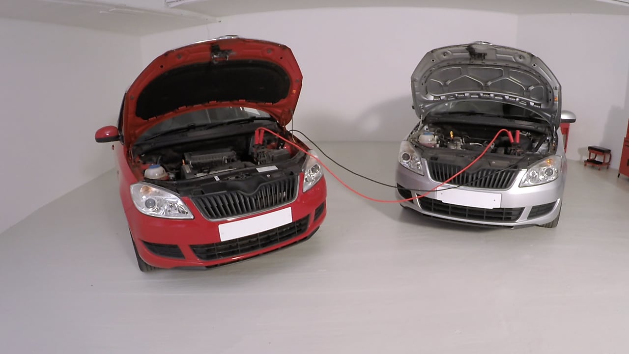 Të lidhura bateritë e makinave të kuqe dhe gri