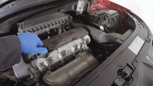 hand checking the dipstick on a car