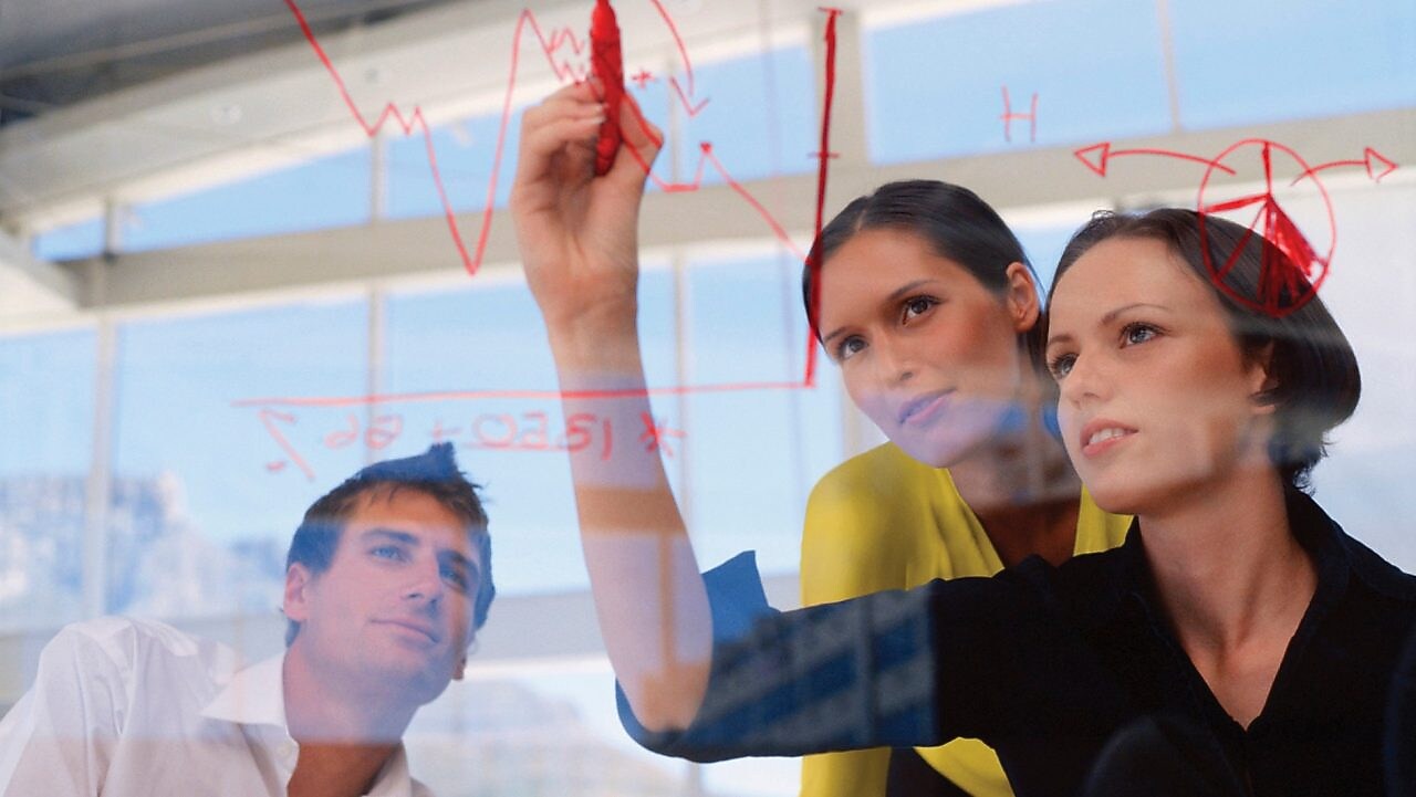 Një sipërmarrëse duke vizatuar grafikë në xham