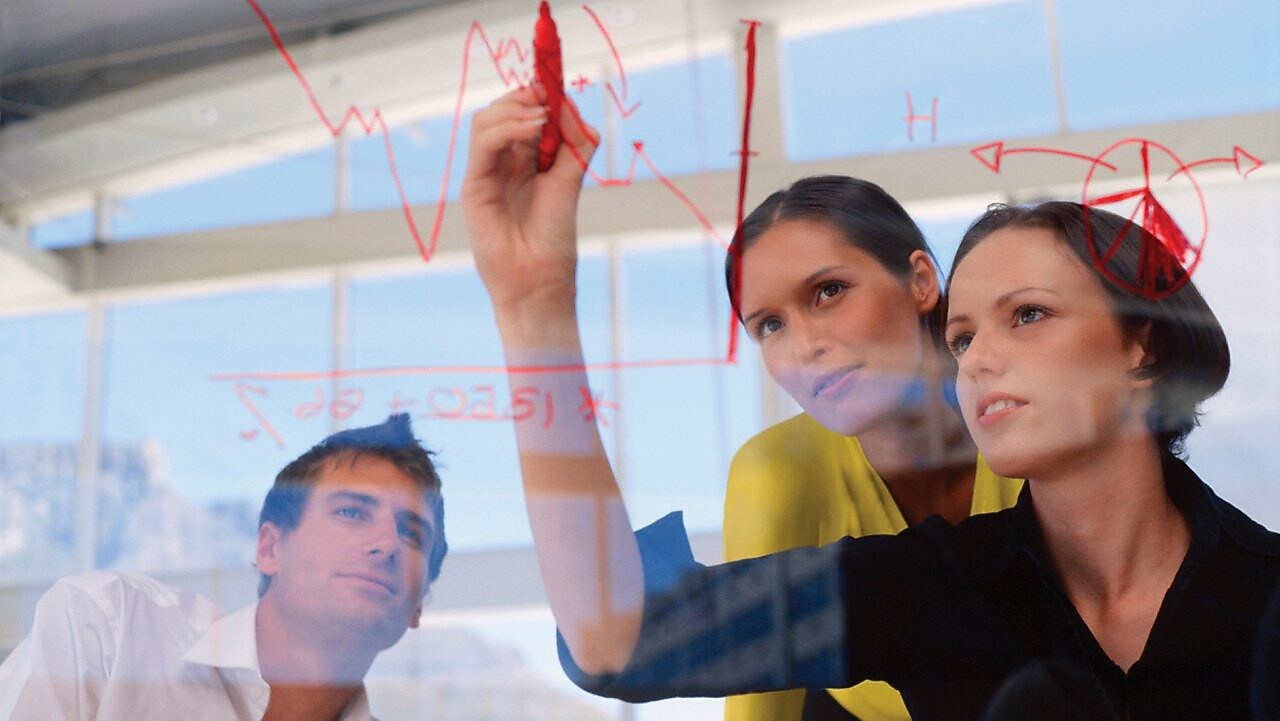 Një sipërmarrëse duke vizatuar grafikë në xham