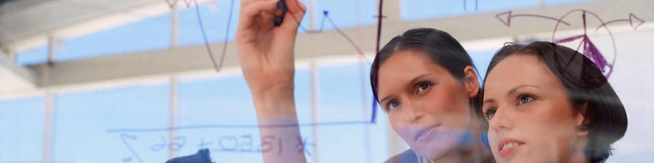 Një sipërmarrëse duke vizatuar grafikë në xham