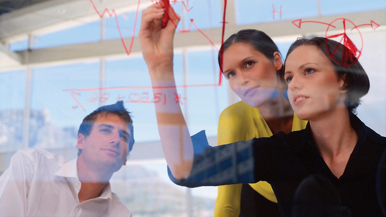 Një sipërmarrëse duke vizatuar grafikë në xham