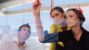 Një sipërmarrëse duke vizatuar grafikë në xham